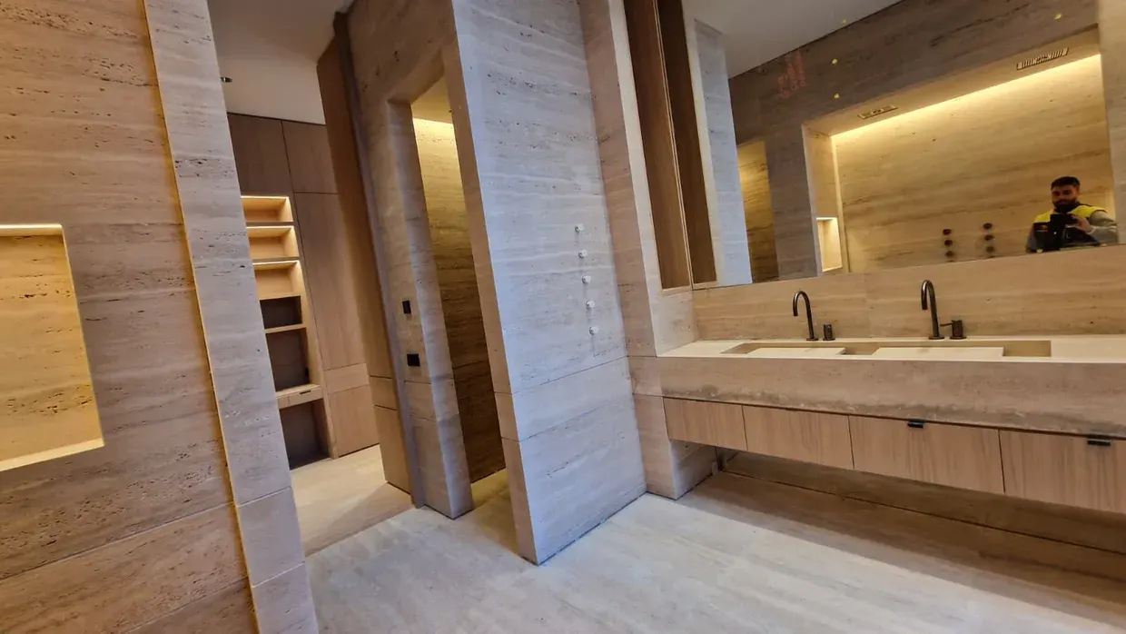 Baño en travertino con doble lavabo, vista lateral
