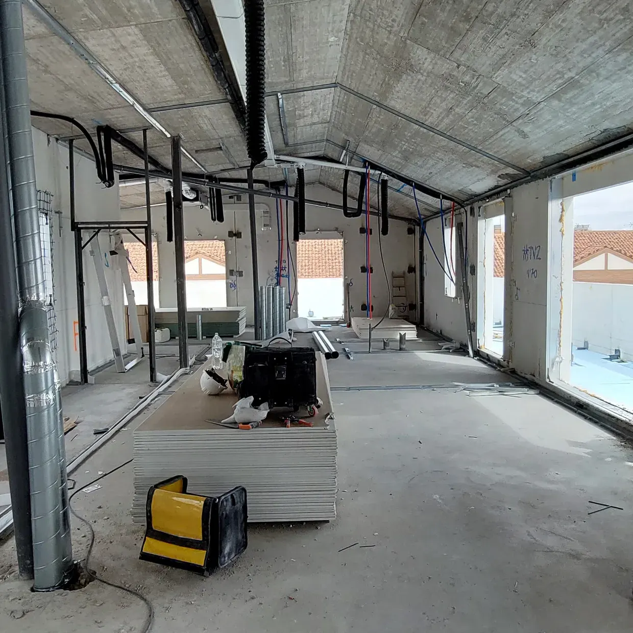 Nave industrial en obra con falso techo y materiales